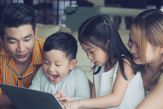 Asian Family Watching Laptop At Home.