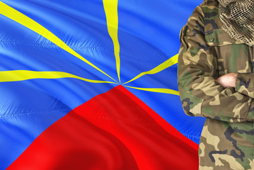 Crossed arms soldier with national waving flag on background - Reunion Military theme.