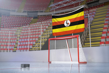 Flag of Uganda in hockey arena with puck and net