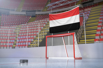 Flag of Yemen in hockey arena with puck and net