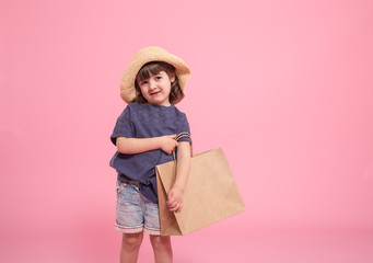 Little girl in summer hat with shopping bag