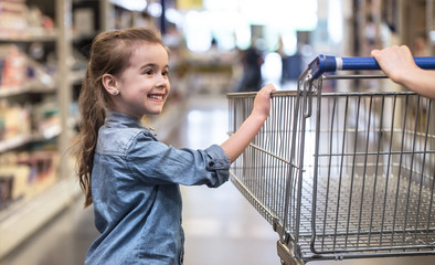 Mother and daughter shopping in supermarket choosing products