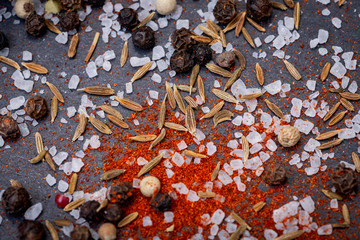 Close up of Spices (Paprika, Thyme, Coarse Sea Salt, Rainbow Peppercorns) on natural stone background.
