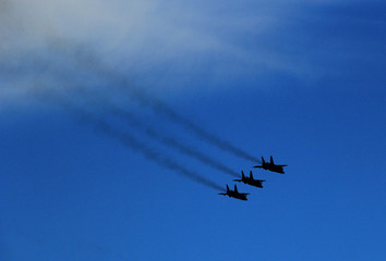 A group of fighters is flying in the blue sky