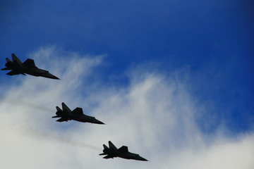 A group of fighters is flying in the blue sky