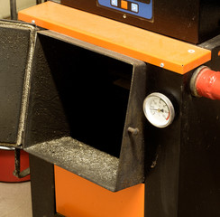 wood burning furnace window with an open door and a manometer on the pipe