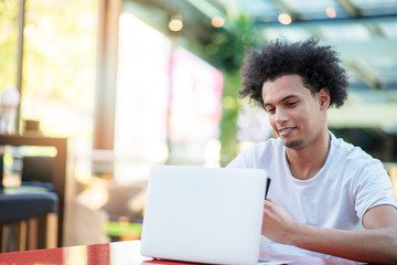 Victorious handsome man looking at his laptop while sitting in bright living room