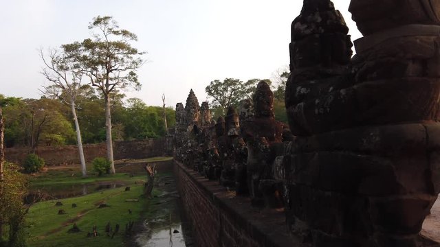stone figures of &ldquo;giants&rdquo; of asuras (evil spirits) and devas (good spirits) along a dam crossing the moat at the south gate of Angkor Thom, among the complex of temples of Angkor