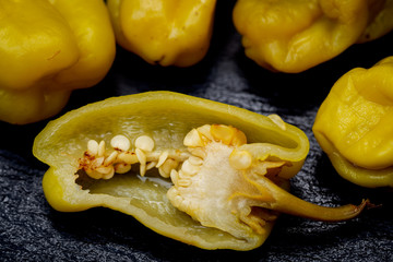 Pickled Golden Greek Peppers, Pepperoncini or Friggitelli (sweet Italian chili pepper) on natural stone background. Capsicum annuum.