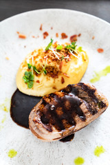 steak with baked potato and sauce