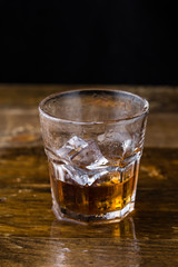 Glass of whiskey on wooden background, close up