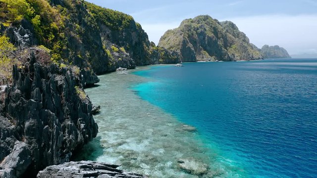 Matinloc island, El Nido, Palawan, Philippines. Aerial view of picturesque sea coast, crystal clear water, sharp cliffs and coral reefs. Unique spot, top touristic destination and must-see place