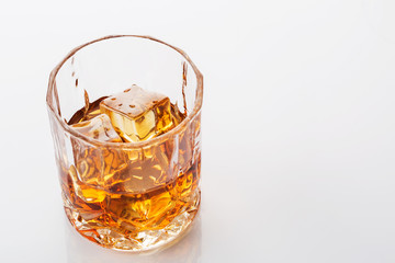 Glass of scotch whiskey on white background