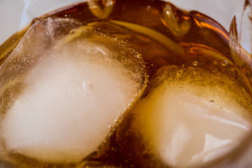 Macro of a glass of whisky. Whisky and ice cube.