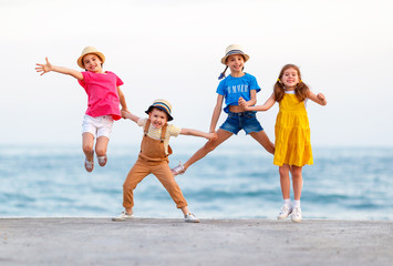 group of happy children jump by   sea in summer.