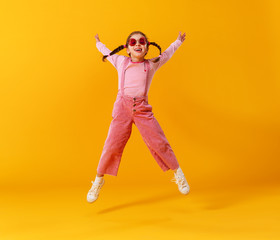 funny funny child girl in pink clothes on yellow background