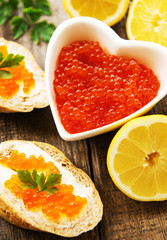 Red caviar in bowl and sandwiches