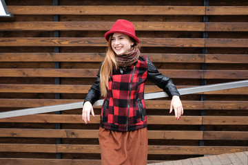 Sensual woman in a red bowler hat with long hair on wooden background. Autumn fashion.