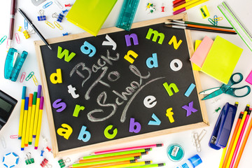 Blackboard with colorful alphabets kids back to school concept, all school and office stationery supplies