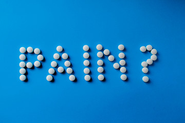 inscription pills on a blue background close up, copy spase
