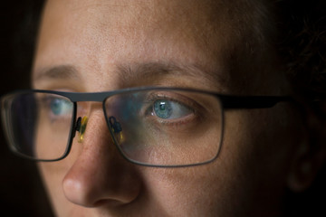girl in glasses with blue eyes looks away
