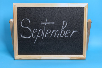 Blackboard with the word chalked september on blue background