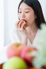 healthy pretty asian woman happiness enjoy eat and love diet with red fresh apple fruit weight loss iedeas concept white room interior background