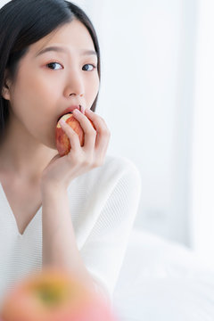 healthy pretty asian woman happiness enjoy eat and love diet with red fresh apple fruit weight loss iedeas concept white room interior background