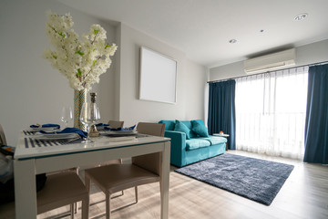 minimal apartment interior design with blue sofa and wooden dining table home interior background