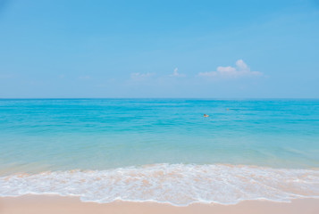 Obraz premium Landscape of tropical beach in summer. Sandy beach with sea waves and blue sky background. Holiday, vacation - Image