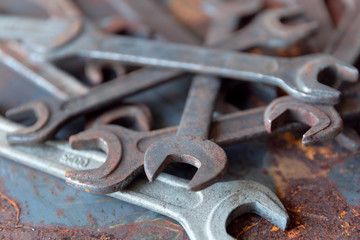 Old rusty wrench over battered metal table rough style. Wrenches top view for construction, industrial, electrician concept design