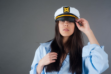 Portrait of young pretty woman in captain hat