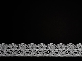 White laces on a black background horizontally in one row