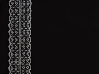 White laces on a black background vertically in row