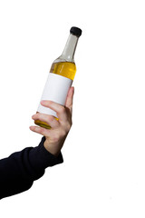 Isolated image of a male hand holding a bottle with alcohol inside with a white blank label on a white background, blank for design. Mocap for alcohol advertising. The concept of alcoholism.