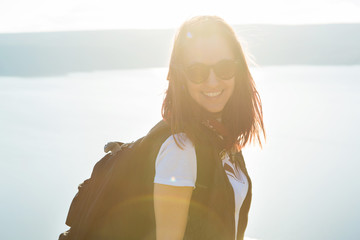 Beautiful girl Trist on top of a mountain on a background of sunset and sea. successful woman hiker...
