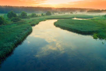 Early misty morning, sunrise over the lake. Rural landscape in summer. Aerial view