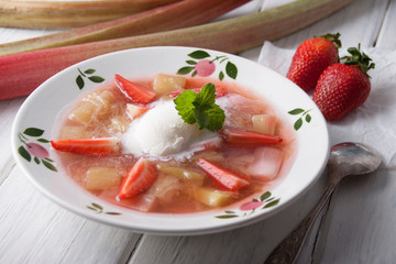 Rhubarb soup with strawberries and ice cream in