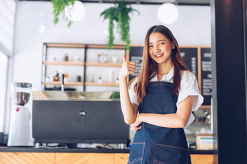 Pretty young asian waitress standing arms crossed in cafeteria.Coffee Business owner Concept. ...