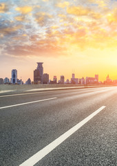 Fototapeta premium Shanghai bund city skyline and empty asphalt highway at sunset