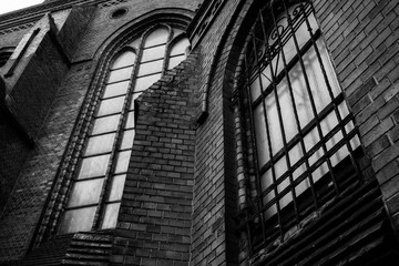 Fototapeta premium Old gothic church with iron bars on the windows dark moody black and white photography