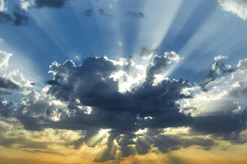 The sun's rays shine through the clouds