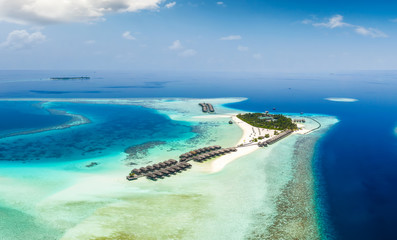 Fototapeta na wymiar Panorama einer Insel auf den Malediven im Süd Ari Atoll mit türkisem Ozean und blauem Himmel 