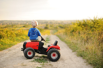 Obraz premium Child with a toy tractor on a trip.