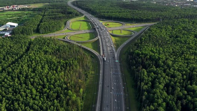 AERIAL. Traffic interchange. Top view of the road, city and forest. Summer video from the drone.