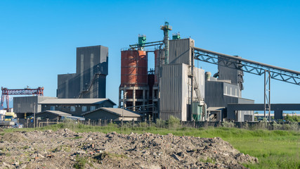 Fototapeta na wymiar Cement factory machinery on a clear blue sunny day
