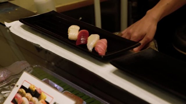 Japanese chef making sushi at restaurant. Closeup of chef hands preparing Japanese food. 