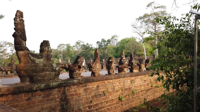 stone figures of &ldquo;giants&rdquo; of asuras (evil spirits) and devas (good spirits) along a dam crossing the moat at the south gate of Angkor Thom, among the complex of temples of Angkor