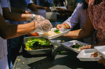 the concept of social inequality : Donating food to beggars to alleviate hunger : The hands of the poor receive food from the hands of the humane