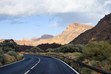 Rotate the road with blur in the foreground while driving and mountains with a volcano in the background
